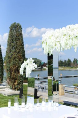 Beyaz harika düğün kemeri, gölün arkasında.