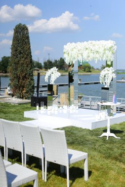 Arkasında göl olan beyaz güzel bir düğün kemeri..