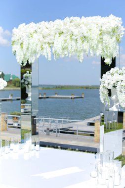 Arkasında göl olan beyaz güzel bir düğün kemeri..