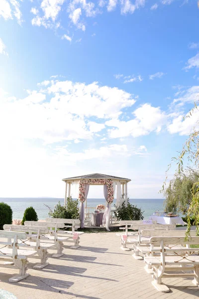 Maravilloso arco de boda decorado con flores con lago en el fondo. — Foto de Stock