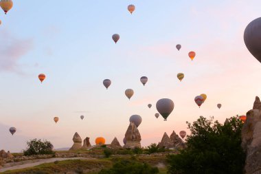 Türkiye 'de günbatımında Kapadokya üzerinde uçan sıcak hava balonları.