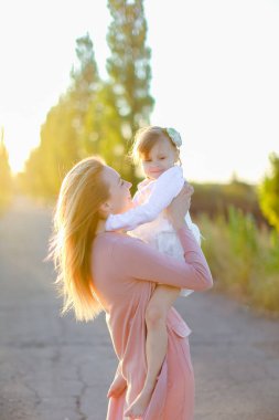 Sarışın anne yolda kız çocuğunu tutuyor..