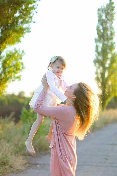 Blonde caucasian mother holding female kid on road. — Stock Photo, Image