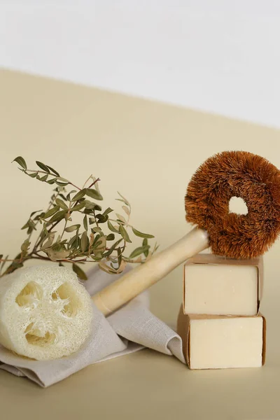 Brosse à vaisselle classique en bois près de savon éco fait main et éponge loofah. — Photo