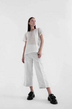 Beyaz minimalist elbise giyen kendine güvenen kadın
