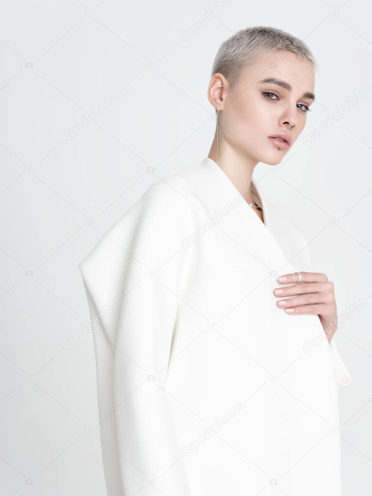 Stylish young woman in white jacket