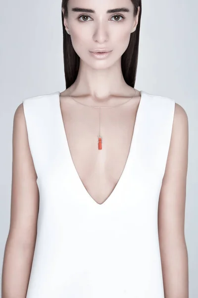 Young female with stylish necklace with orange gemstone