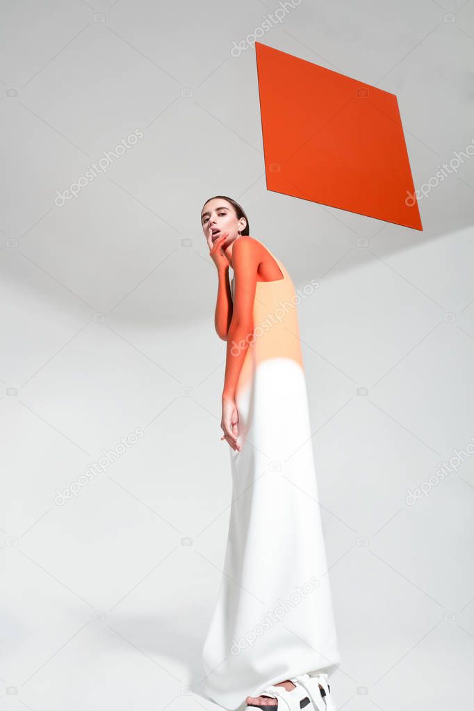 Young trendy woman with orange limelight square behind