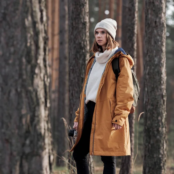 年轻沉思的女摄影师站在森林中 — 图库照片