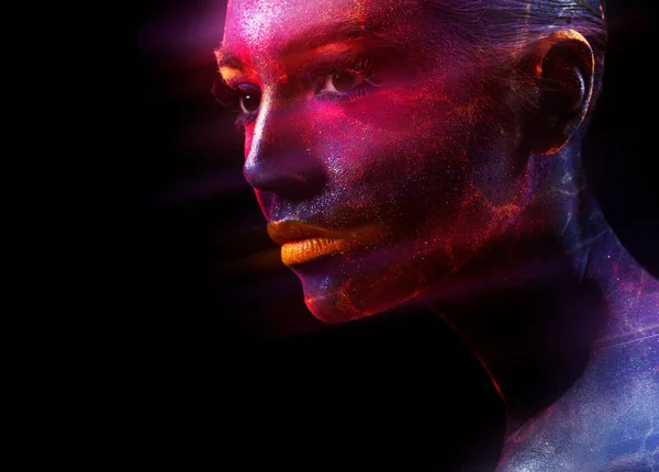 Mysterious female model with face painted in shiny multicolored paints with sparkling veins looking away against black background