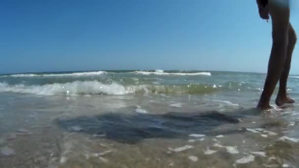 Mladý muž kráčí po pláži — Stock video