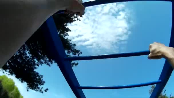 Hombre haciendo gimnasia en el parque en pull-up bar, sujetándose POV — Vídeos de Stock