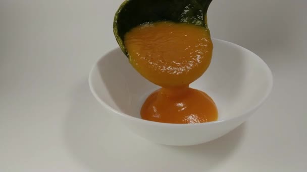 奶油南瓜汤从汤包倒入白盘和背部无缝循环 — 图库视频影像