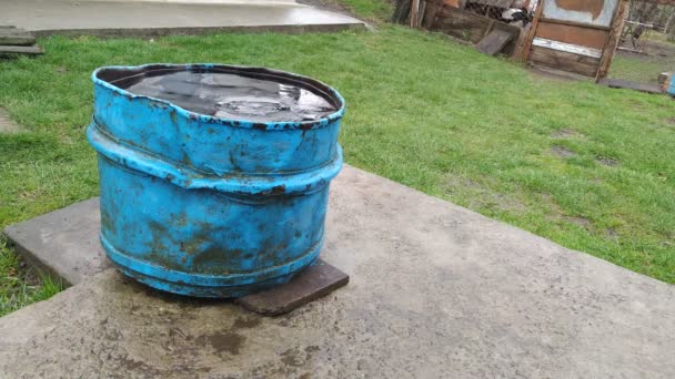 Agua de lluvia que fluye en el viejo barril oxidado vista lejana — Vídeo de stock