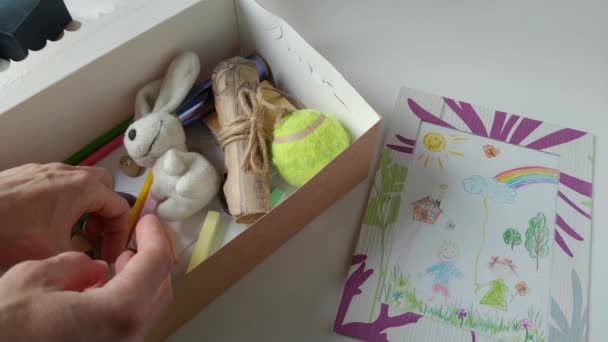 Kvinna leker med en barnleksaker från en låda — Stockvideo