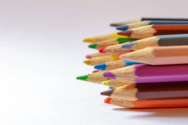 Açık arkaplanda renkli kalemler, seçici odak.