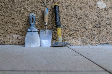 Granit kiremitler yerleştirildikten sonra duvardaki tuğla ustasının araçları.