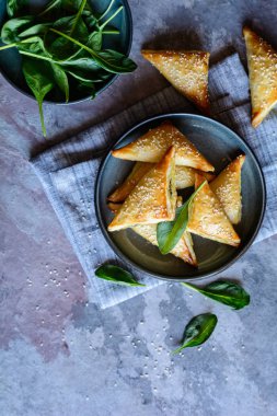 Ispanak ve peynir ile doldurulmuş taze pişmiş Spanakopita üçgenler