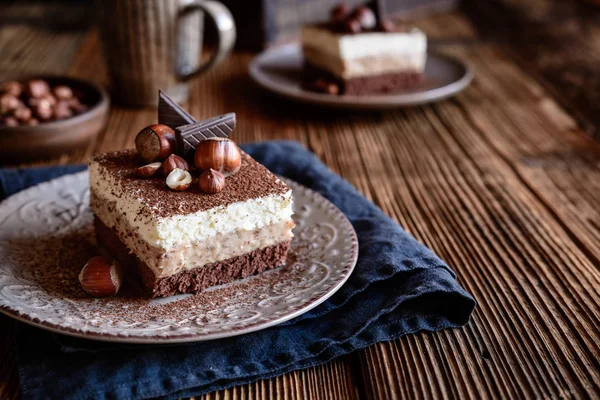 Delicious chocolate sponge cake with hazelnut and whipped cream layers, topped with cocoa powder