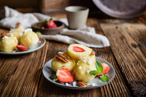 Traditional sweet dumplings stuffed with strawberries topped with curd