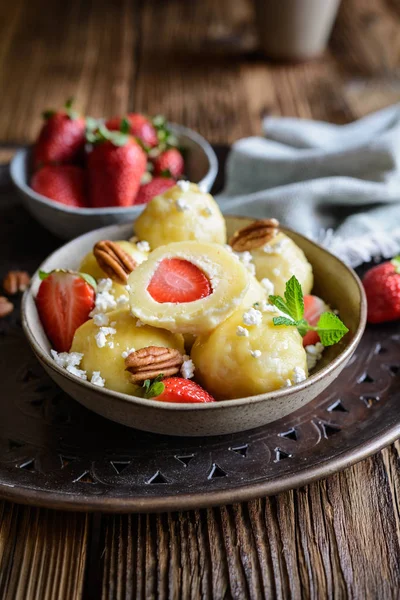 Traditional sweet dumplings stuffed with strawberries topped with curd