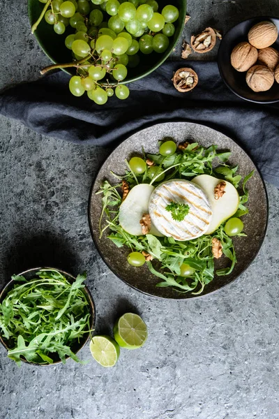 Brânză la grătar Camembert cu arugula proaspătă, struguri verzi, pere și nuci — Fotografie, imagine de stoc