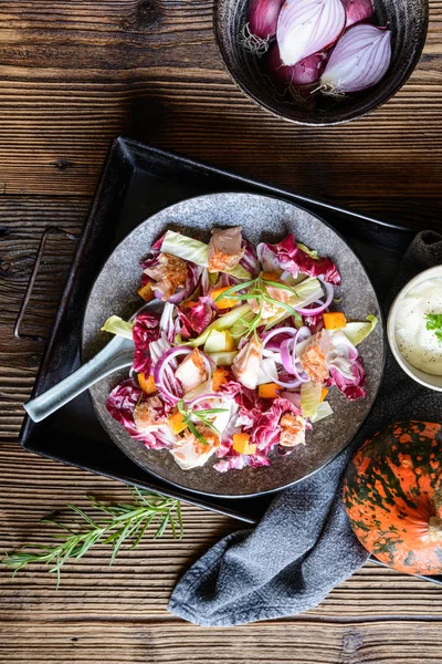 Овощной салат с красным и белым цикорий, запеченные части форели, лук и жареный сквош Хоккайдо — стоковое фото