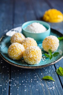 Mango hindistan cevizi ladoo, geleneksel mango püresi, kurutulmuş hindistan cevizi ve konsantre sütten yapılmış tatlı toplar.