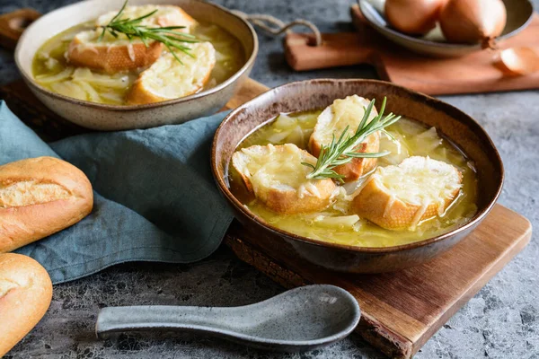 自制的经典法国洋葱汤 放在陶瓷碗里 上面有面包片和切碎的奶酪 — 图库照片