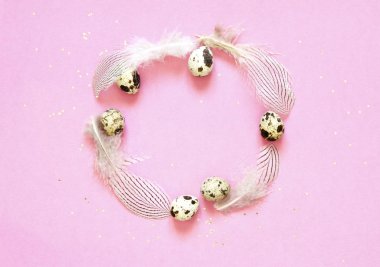  Çerçeve ile bıldırcın yumurtası, tüyler ve ve pembe bir arka plan üzerinde altın glitter.