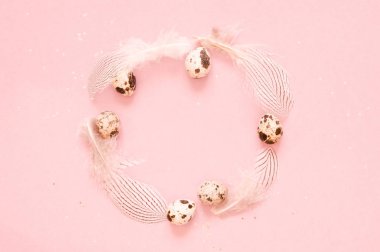  Çerçeve ile bıldırcın yumurtası, tüyler ve ve pembe bir arka plan üzerinde altın glitter.