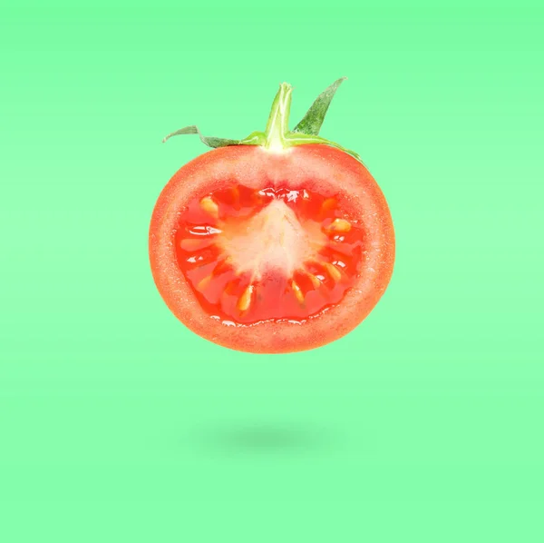 Halbe Tomate Die Der Luft Über Grünem Hintergrund Fliegt Ernährungsschwebekonzept — Stockfoto