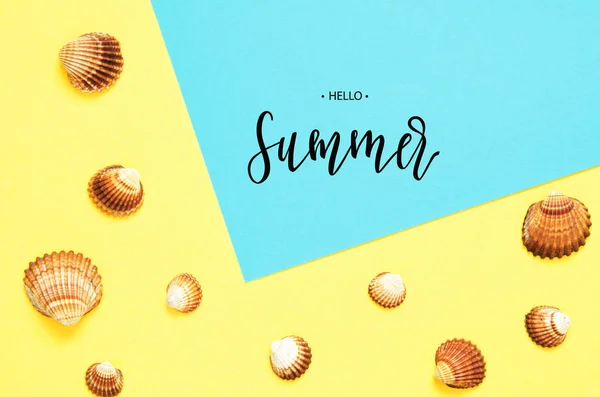 Inscription Hello Summer. Sea shells pattern on  turquoise and yellow paper background. Summer concept. Flat lay, top view - Image