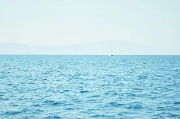 海水表面和海浪延伸到地平线 在那里可以看到远处的岛屿 — 图库照片