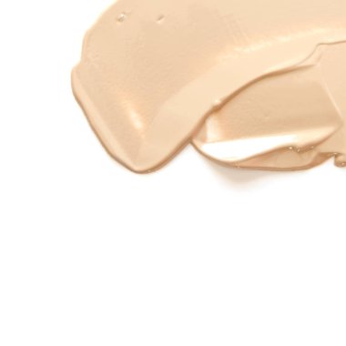 Kremsi vakfın bej makyaj lekesi beyaz arka planda izole edilmiş. Moda ve güzellik endüstrisi kavramı. - Görüntü