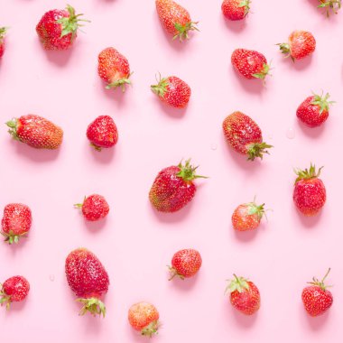 Pembe arka planda çilek. Düz yatıyordu, üstten bak. - Resim