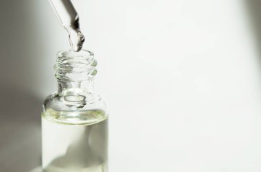 Beyaz arka planda pipet ile kozmetik veya tıbbi cam şişe. Cilt Bakımı kavramı. Doğal sert ışık, derin gölgeler. -Görüntü