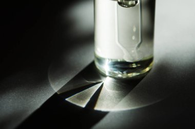 Pipet ile kozmetik veya tıbbi cam şişe. Cilt Bakımı kavramı. Doğal sert ışık, derin gölgeler. -Görüntü