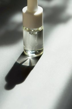 Pipet ile kozmetik veya tıbbi cam şişe. Cilt Bakımı kavramı. Doğal sert ışık, derin gölgeler. -Görüntü