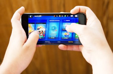 Yekaterinburg, Rusya-26 Temmuz 2019: çocuk iOS iPhone üzerinde SuperCell tarafından geliştirilen ve yayımlanan ücretsiz bir mobil oyun Dövüş yıldızları oynar. -Görüntü