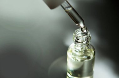 Pipet ile kozmetik veya tıbbi cam şişe. Cilt Bakımı kavramı. Doğal sert ışık, derin gölgeler. -Görüntü