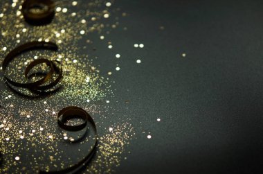 Siyah arka planda altın parıltılar ve kurdeleler. Şenlikli konsept. - Resim