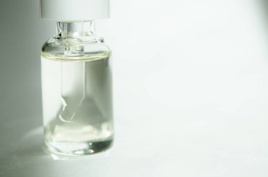 Beyaz arka planda pipet ile kozmetik veya tıbbi cam şişe. Cilt Bakımı kavramı. Doğal sert ışık, derin gölgeler. -Görüntü