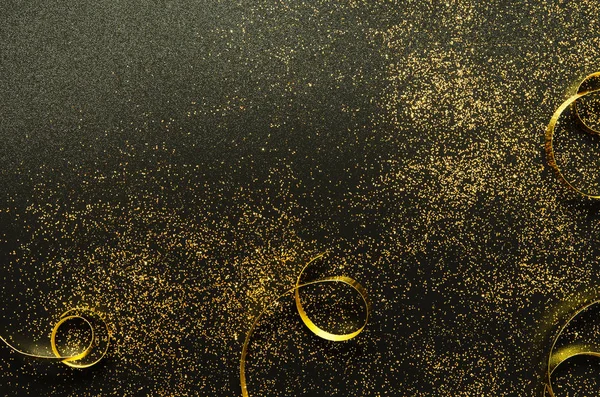 Golden sparkles and ribbons on black background. Festive concept. - Image