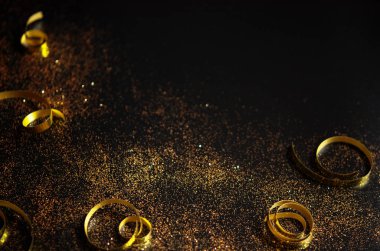 Siyah arka planda altın parıltılar ve kurdeleler. Şenlikli konsept. - Resim