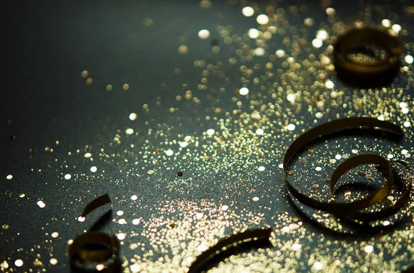 Siyah arka planda altın parıltılar ve kurdeleler. Şenlikli konsept. - Resim