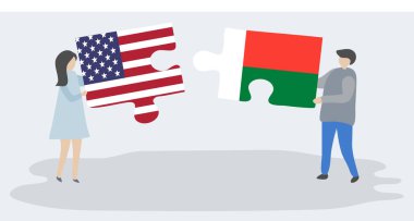 Amerikan ve Malagasy bayrakları ile iki bulmaca parçaları tutan çift. Amerika Birleşik Devletleri ve Madagaskar ulusal sembolleri birlikte.
