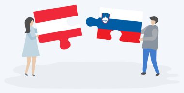 Avusturya ve Sloven bayrakları ile iki bulmaca parçaları tutan çift. Avusturya ve Slovenya ulusal sembolleri bir arada.