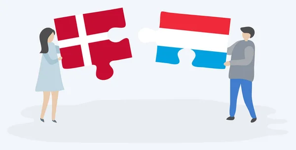 デンマークとルクセンブルクの旗を持つ2つのパズルピースを保持しているカップル デンマークとルクセンブルクの国のシンボル — ストックベクタ