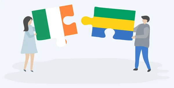 Para Trzyma Dwa Kawałki Puzzli Irlandzkim Gabońskim Flagi Symbole Narodowe — Wektor stockowy